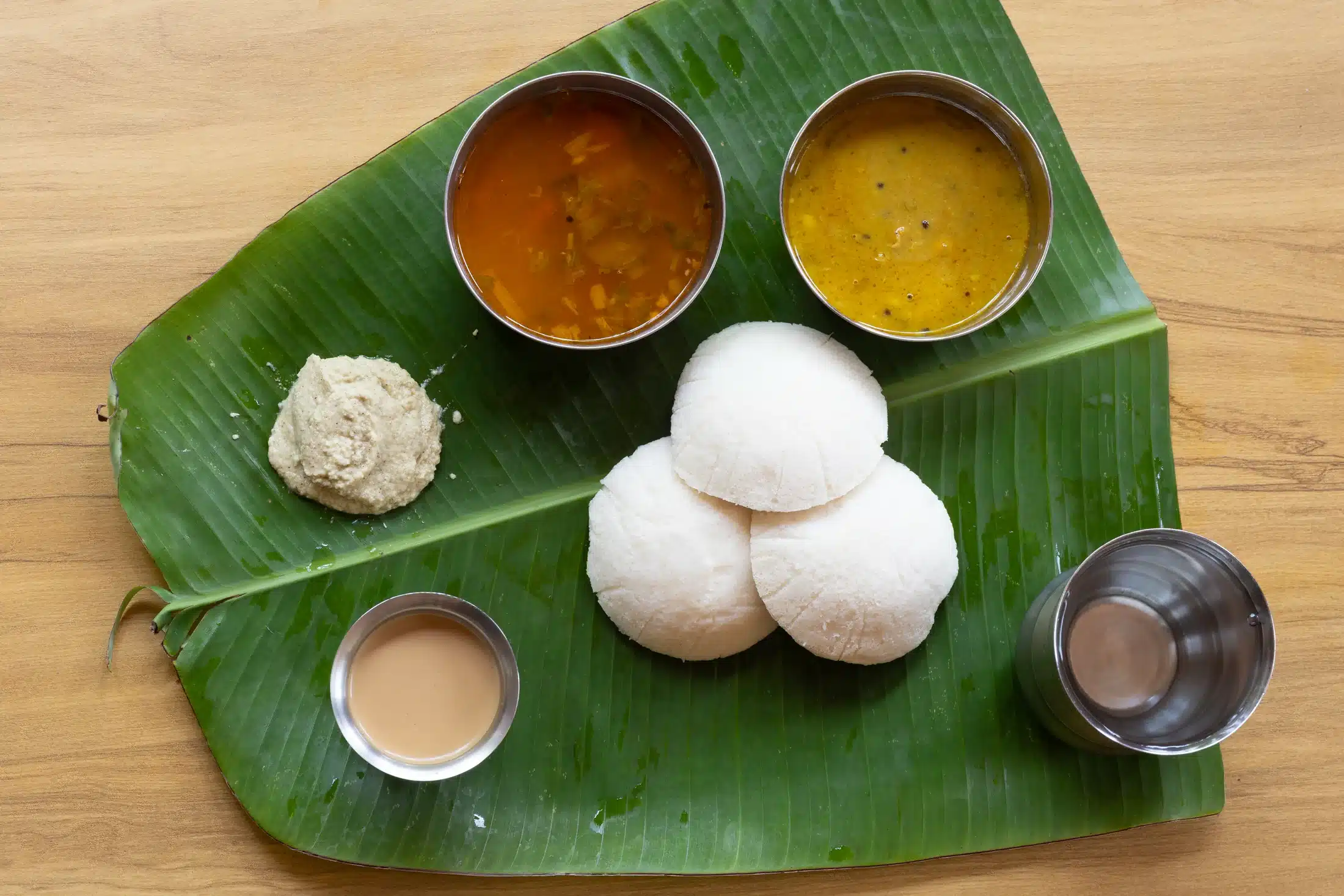 Home Idli with chutney, curries and tea on a banana leaf at Lopez Paradise.