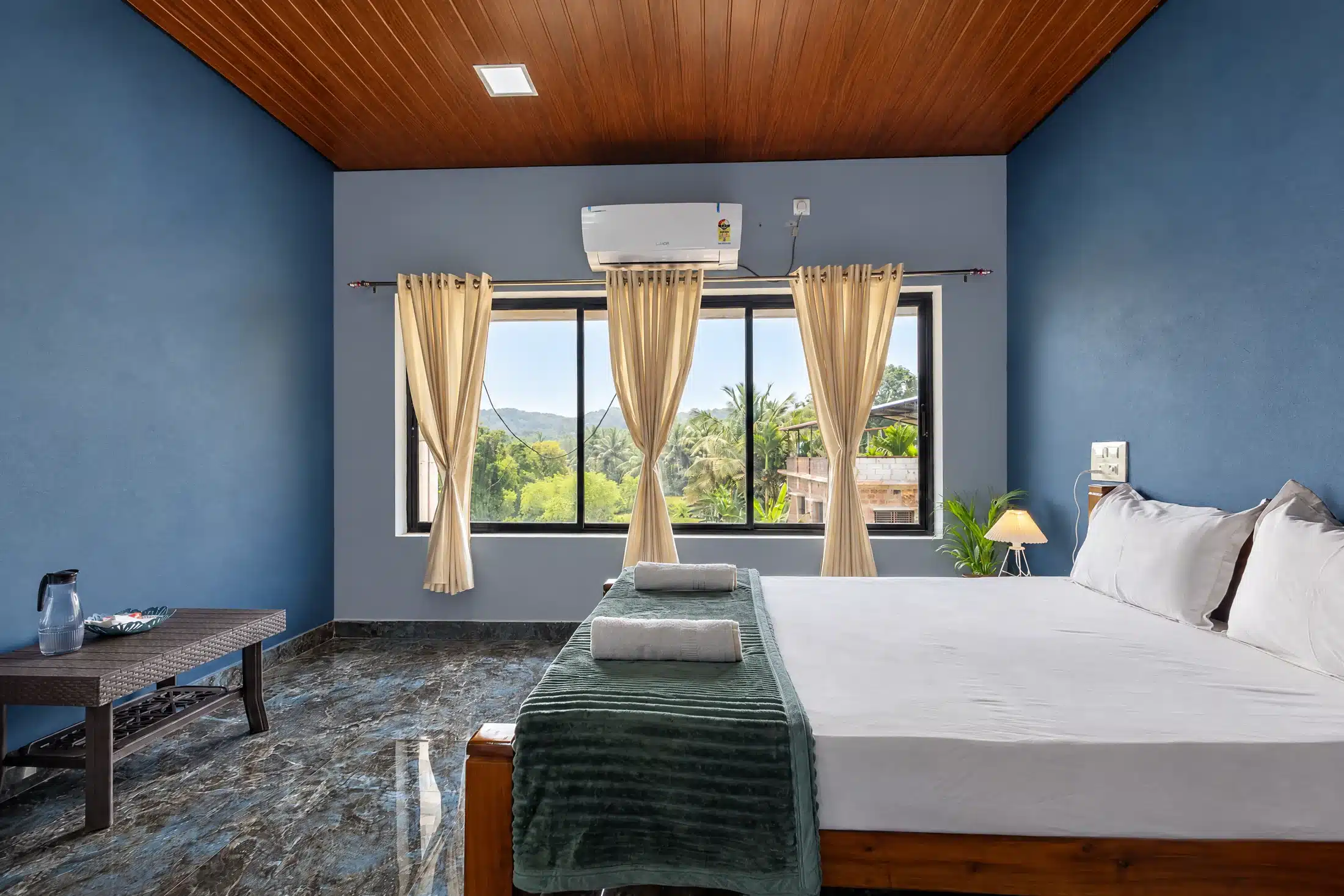 Premium couple room viewed from a second angle, with queen bed and blue accent wall